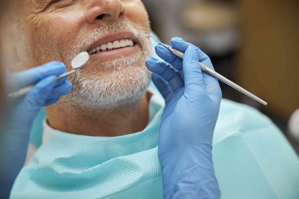 Smiling patient receiving a dental implant examination.