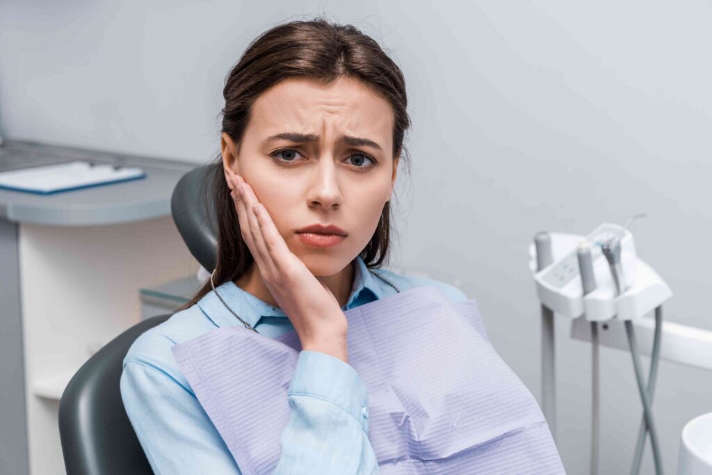 Patient with a toothache in a dental chair.