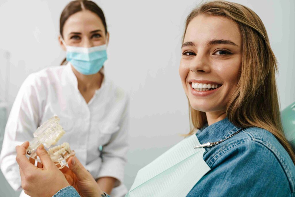 Smiling patient holding a dental model.